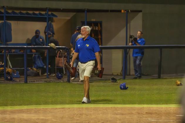 FBHS Athletic Director Mike Woodard carries the district champions and runners-up trophies. Photo by Ashley Chandler/News-Leader