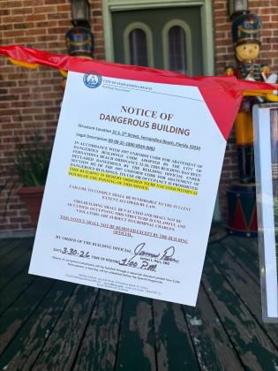 Photo 2: The sign tacked outside of Hola! Cuban Cafe hung to notify the public of the dangerous structure. By Marisa DeMar  News-Leader 
