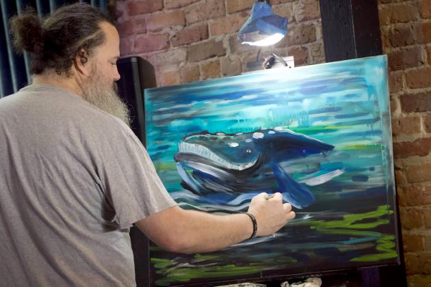 Brian Barnard paints a whale for the raffle during the Whale Baby Shower hosted by the Amelia Island Whale Ambassadors on Wednesday. Photo Marisa DeMar/News-Leader