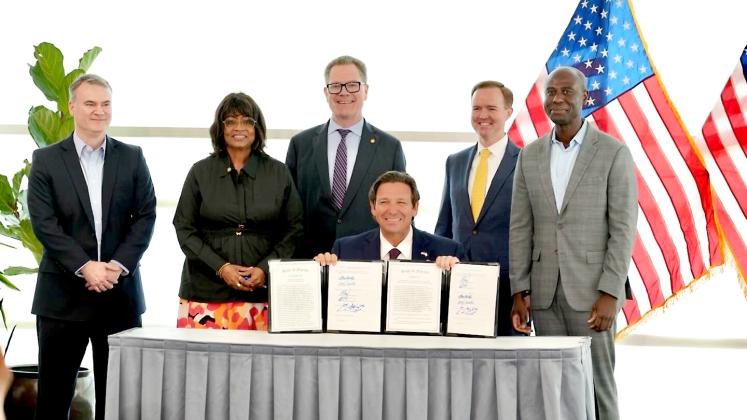 Gov. Ron DeSantis shows two bills he signed on Wednesday in Jacksonville. Photo provided by News Service of Florida