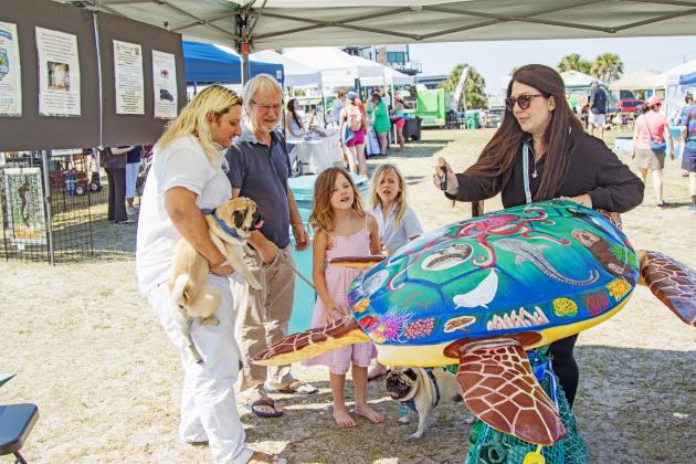 Artist Tina McDaniel shows off her art work "Scout" to education children on plastic pollution at the Sea Turtle Festival. Photo by Ashley Chandler/News-Leader