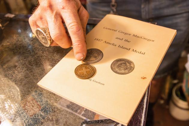 Nick Drakus, co-owner of Ice House Antiques, talks about the MacGregor Medallion. Photo by Ashley Chandler/News-Leader