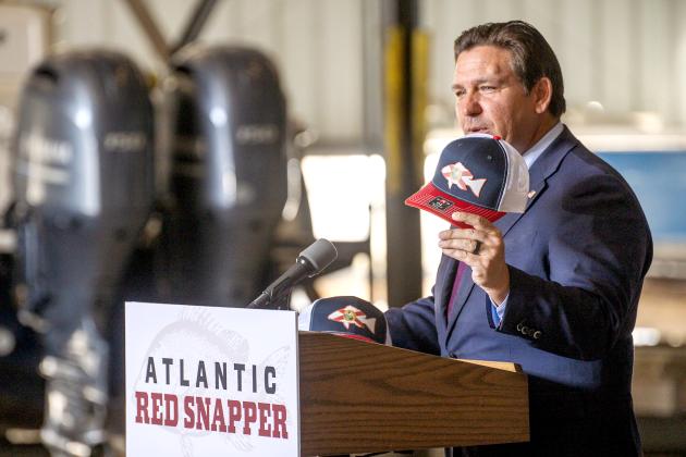 Gov. Ron DeSantis holds a red snapper hat while announcing an extended red snapper season on Monday at the Amelia Island Marina. Photo by Nick Blank/News-Leader