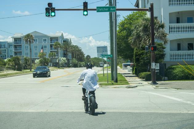 A person rides an e-bike May 20 at the intersection of North Fletcher and Atlantic Avenue. Photo by Ashley Chandler/News-Leader