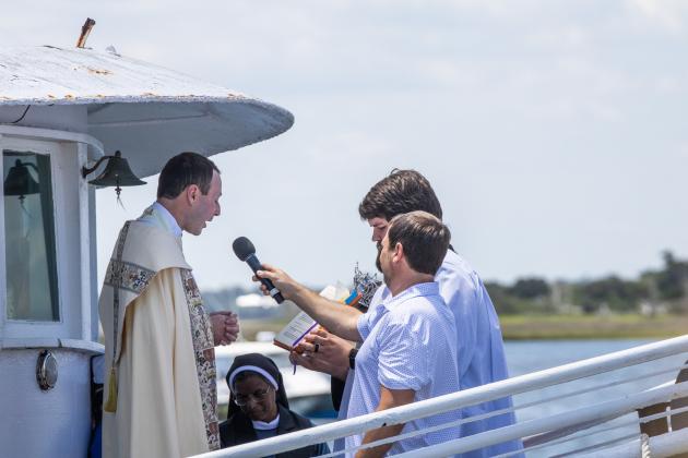 Father Eric Stelzer of St. Michaels Catholic Church blesses the fleet Sunday at the 61st Annual Eight Flags Shrimp Festival. Photo by Nick Blank/News-Leader