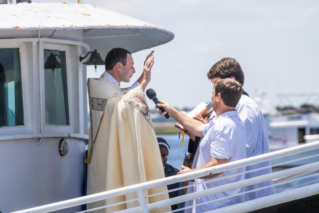 Father Eric Stelzer of St. Michaels Catholic Church blesses the fleet Sunday at the 61st Annual Eight Flags Shrimp Festival. Photo by Nick Blank/News-Leader