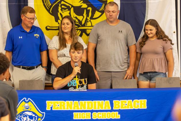 Conner Bayless, middle, speaks Wednesday after he signed his letter of intent to play baseball at Daytona Beach Christian University. He is surrounded by his family and FBHS baseball head coach Jon Shave. Photo by Ashley Chandler/News-Leader