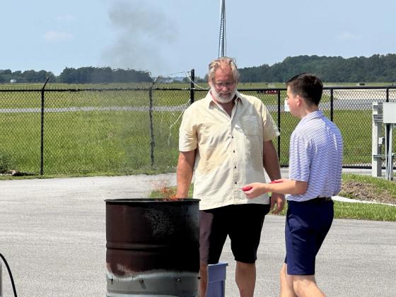 Above, Bruce Senter, husband of a Daughter of the American Revolution; and Eli Maddox, president of the Children of the American Revolution, take part in the ceremony to retire a Flag of the United States of America on Saturday at Fernandina Beach Fire Station 2. Submitted