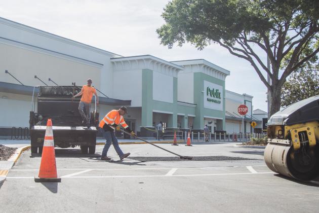 Donald Johnson, right, and Dalton Pinner of Duval Asphalt put finishing touches on the Publix parking lot Thursday. Johnson said they did all the paving and printing of the lot. Publix has officially announced it will open on July 2. Photo by Ashley Chandler/News-Leader