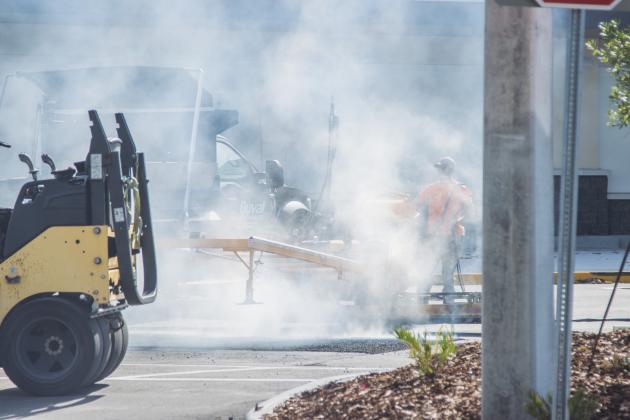 Dalton Pinner of Duval Asphalt puts finishing touches on the Publix parking lot Thursday. Johnson said they did all the paving and printing of the lot. Publix has officially announced it will open on July 2. Photo by Ashley Chandler/News-Leader