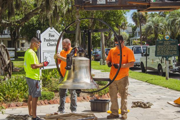 Workers from White’s Clock and Carillion assemble the bell wheel on the restored bell Tuesday at First Presbyterian Church.