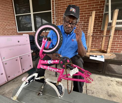 John Gilbert helps fix a bike. Submitted photo