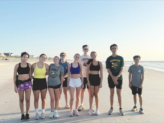 YHS boys and girls cross country runners during a summer training session on the beach. Courtesy of YHS cross country