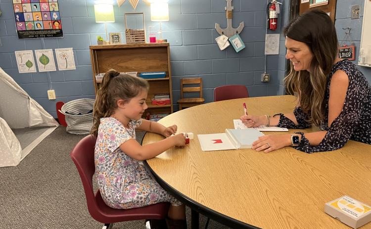 School psychologist Sarah Davis leads her daughter through an IQ test in her office with a tee-pee in the corner and filled with sensory toys to help children calm their more difficult emo-tions.