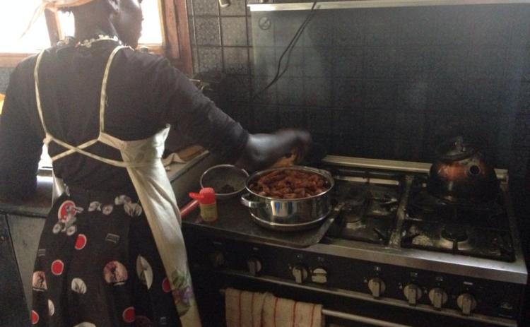 A culinary student at Sonrisa Culinary School and Bakery cooks stew over a stovetop at the school.