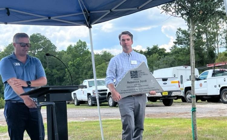 UF/IFAS Nassau County Extension Director Taylor Clem carries a plaque honoring Rebecca L. Jordi, for whom the new extension office is named.