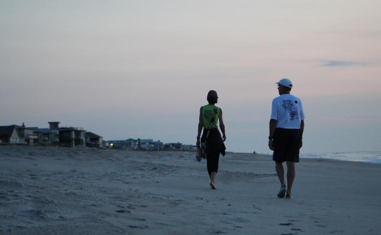 Volunteers Jan and Eric Linden walk Sadler Beach before the sun has risen, keeping an eye out for turtle tracks leading to a nest.