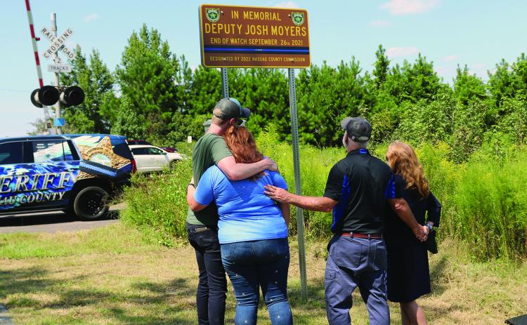 Joshua Moyers’ fiancée Ivy Carter, mom Brenda Moyers and brother Jordan Moyers look at the sign with Tim. Photo by Kathie Sciullo/Nassau County Record.