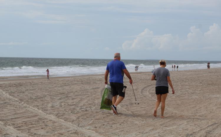 Volunteers keep an eye out for litter as they wander up Main Beach. Holly Dorman/News-Leader