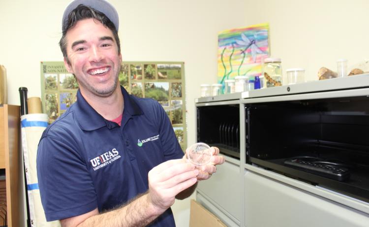 Dr. Taylor Clem with one of the many specimens of bugs, branches and animals studied by the UF Extension office. “I love my job,” he said. “Some days you get a little head spun because you have so many things going on at the same time, but that’s OK. I will probably have someone call me today to ask about a palm tree or a person bring a bug sample in. Every day is different and that’s why I love it.”