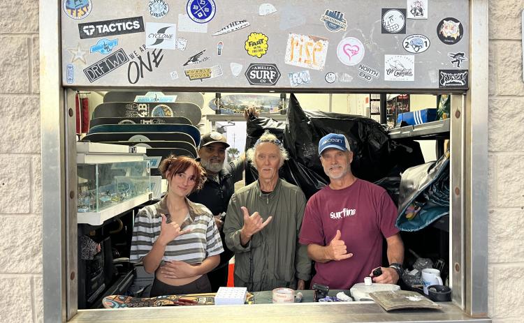 From left, Bella Peters, Wally Borrero, Ken Pinson and Mike Nichols look through the window of Dina’s Skate Shack. Photo by Sean Rosenthal/News-Leader