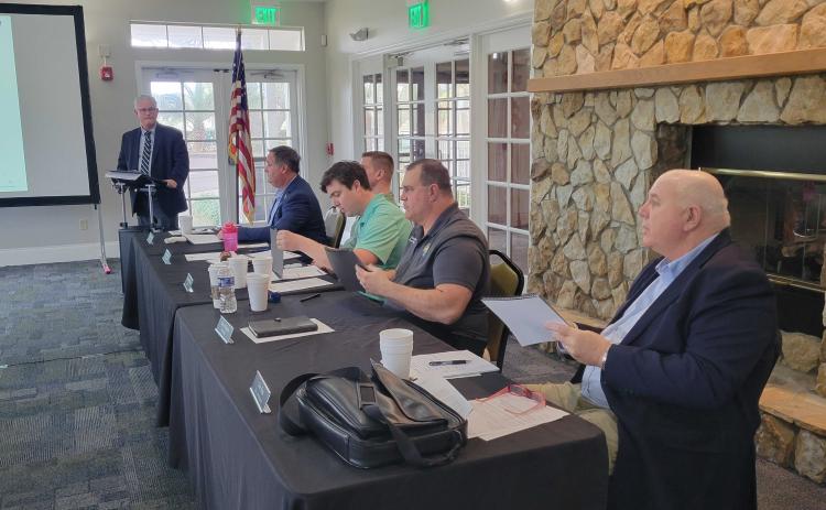 Financial consultant Mark Galvin, standing, addresses the Fernandina Beach City Commission, from left, Darron Ayscue, James Antun, Mayor Bradley Bean, David Sturges and Chip Ross, about the steps that need to be taken to ask voters to approve a bond. In order to get the matter on the November ballot, the language put to voters has to be approved by May 17. Photo by Julia Roberts/News-Leader
