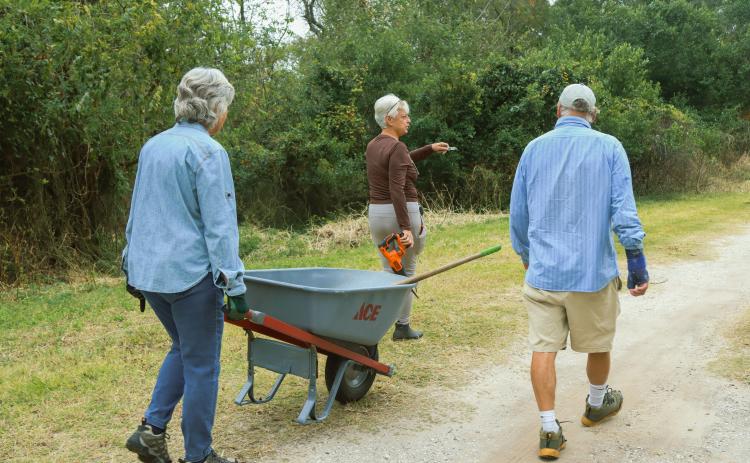 Kathy Russell, conservation and environmental manager for city of Fernandina Beach, leads volunteers during an Invader Raiders cleanup event in December on city conservation land. The group was working to clear trash, debris and invasive plant species from the property. Photo by Ashley Chandler/News-Leader