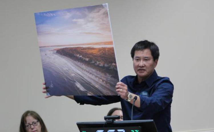 In April 2023, Peter Brual showed the Nassau County Board of County Commissioners and the audience a picture of the south end of Amelia Island, asking the BOCC to vote against a settlement that would allow 85-foot condominiums to be built. “This is a picture of the crown jewel of the whole area,” Brual said. “It’s why we’re here. Think about, if Riverstone wins, what this might look like. Can you see it? Towers over canopy treetops.” File photo/News-Leader