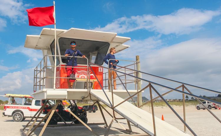 Fernandina Beach lifeguards Adalai Kwiatkowski and Evan Main stand next to the red flag signaling hazardous ocean conditions on Tuesday.
