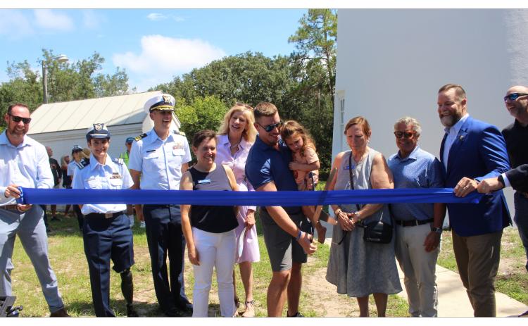 Mayor James Antun and his daughter cut the ceremonial ribbon. Also pictured, commissioners Joyce M Tuten, Genece Minshew, Tim Poynter, Congressmen Aaron Bean, Jeremiah Glission, and members of the Coast Guard. Photo by Marisa DeMar/News-Leader