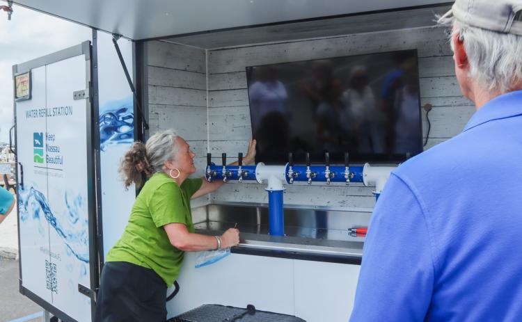 Lynda Bell, executive director of Keep Nassau Beautiful, shows off the new water cart. Photo by Ashley Chandler/News-Leader