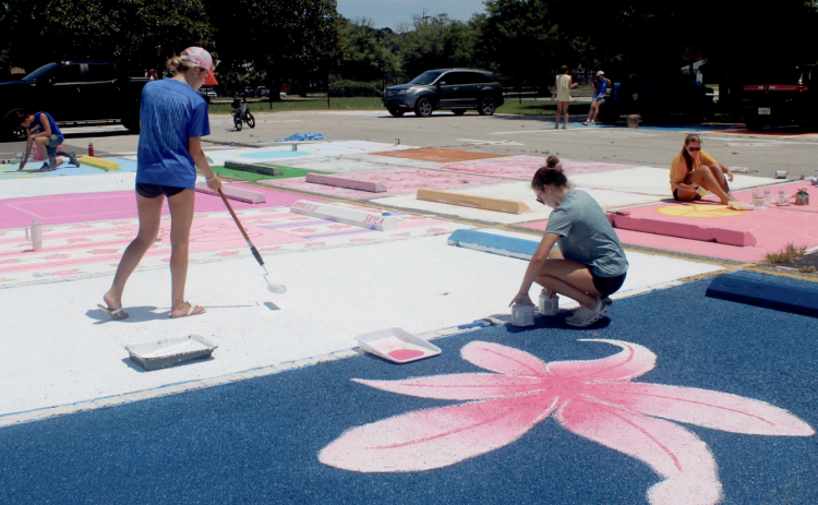 Amelia Oliver and Emma Gunn, FBHS seniors, raise money through painting parking spaces. Photo by Marisa DeMar/New-Leader