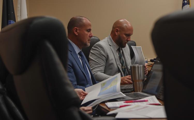 From left, Assistant County Manager Marshall Eyerman and County Manager Taco Pope look over maps presented by President of Save Historic American Beach Inc. Mark Dawkins at the Aug. 11 Board of County Commissioners meeting. Photo by Ashley Chandler/News-Leader