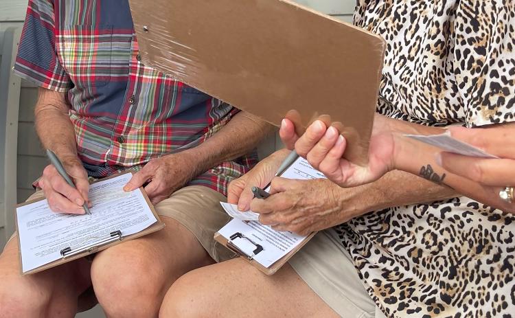 Residents sign petition forms in August in an effort to get Paid Parking put to a vote. On Monday, Supervisor of Elections of Nassau County Janet H. Adkins signed the official Initiative Petition Certification. File photo/News-Leader