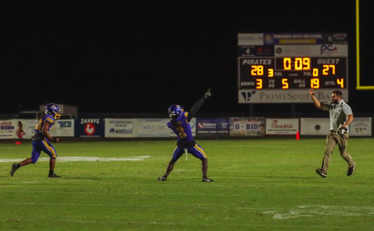Fernandina Beach’s Traivon Martin, left, and Aydin Poe run to the bench to celebrate with coaches and teammates as the clock runs out Friday night in a 1-point win over the Fort White Indians.. Photo by Ashley Chandler/News-Leader