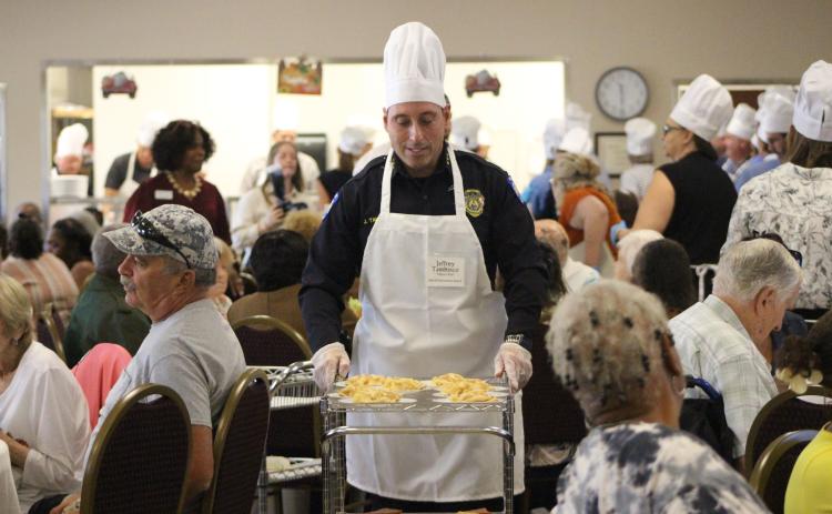 Jeff Tambasco, Fernandina Beach Police Chief serves pies at the NCCOA Thanksgiving Luncheon. By Marisa DeMar/News-Leader
