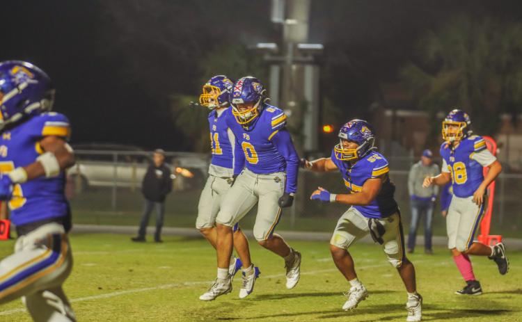 Pirates defensive end Kalani Tucker, 0, and teammates celebrate a pick-6 against the Bell High Bulldogs. Photo by Ashley Chandler/News-Leader