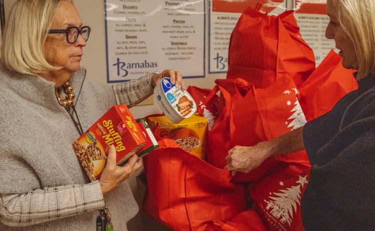 President and CEO of Barnabas Center, Jamie Reynolds, left, shows some donated food items to Anne Gower, co-chair of the Campaign Committee, on Monday at Barnabas Center. Photo by Ashley Chandler/News-Leader