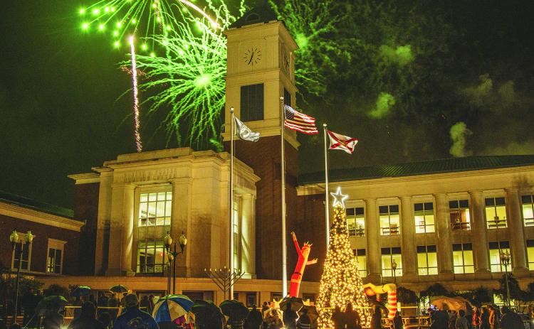 Attendees of the Nassau County tree lighting event Friday watch the fireworks that followed the lighting from under umbrellas at the Robert M. Foster Justice Center in Yulee. Photo by Ashley Chandler/News-Leader