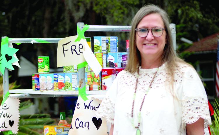 Becky Dewitt stands next to her front yard food pantry on S 14th Street after the code enforcement officer visited her home.  By Marisa DeMar/News-Leader 
