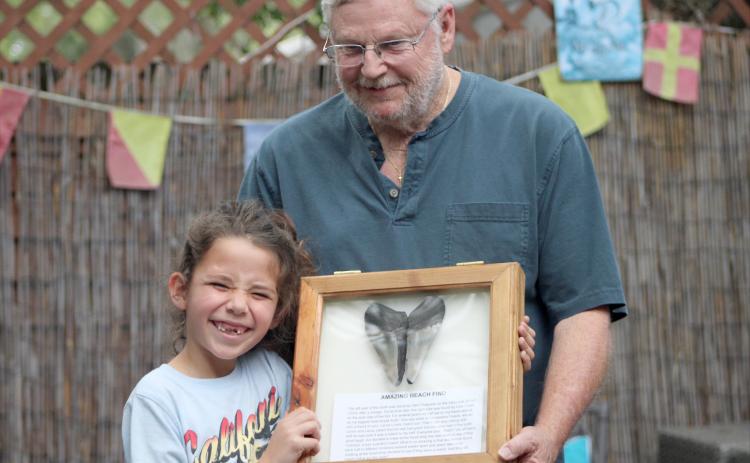 Remy Hayes and Herb Ferguson pose with the shark tooth match that sparked the idea for the speed dating event. By Marisa DeMar/News-Leader