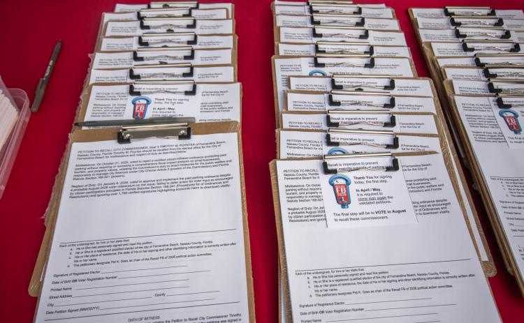 Petitions aligned on the table of Recall FB 2026 farmers market booth at the mid-week farmers market on 14th and Lime. Marisa DeMar/News-Leader
