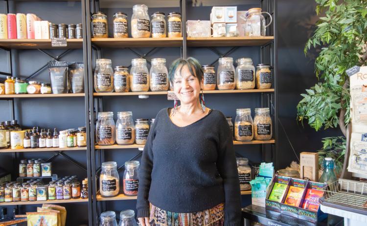 Jill Vozza, the owner of Sand and Sage Mystic Shoppe, stands in front of the wall of herbal teas at the store on Atlantic Avenue. Photo by Marisa DeMar/News-Leader