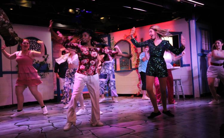 The ensemble and lead actor Samantha Anderson as Sophie on the right, performs a dance number in Amelia Musical Playhouse's rendition of Mamma Mia.  By Marisa DeMar