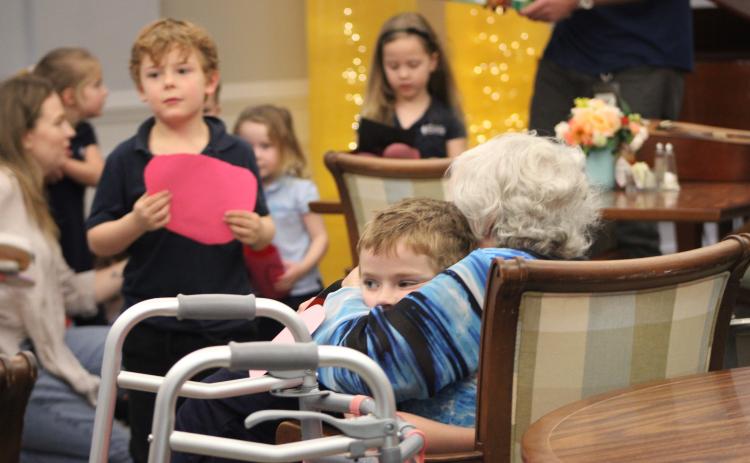 Osprey Village resident hugs Montessori student after he gave her a Valentine's Day card.  By Marisa DeMar/News-Leader