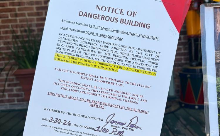 Photo 2: The sign tacked outside of Hola! Cuban Cafe hung to notify the public of the dangerous structure. By Marisa DeMar  News-Leader 