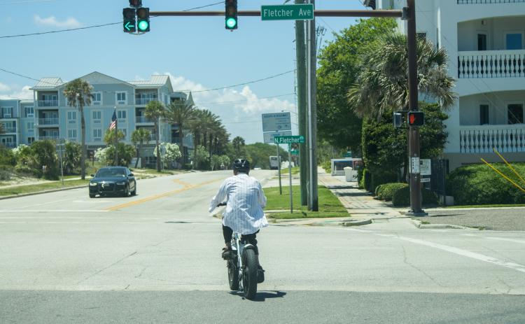 A person rides an e-bike May 20 at the intersection of North Fletcher and Atlantic Avenue. Photo by Ashley Chandler/News-Leader