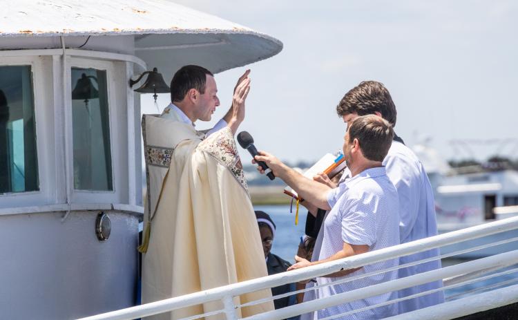 Father Eric Stelzer of St. Michaels Catholic Church blesses the fleet Sunday at the 61st Annual Eight Flags Shrimp Festival. Photo by Nick Blank/News-Leader