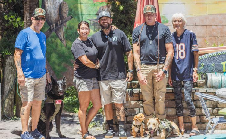 From left, Rick Ludwig with his dog Raven, Angela Young, Matt Tarlton with Copper, Scott Lempe’s dog, Thomas Gritzner with Payton and his caretaker, Anna Gritzner.