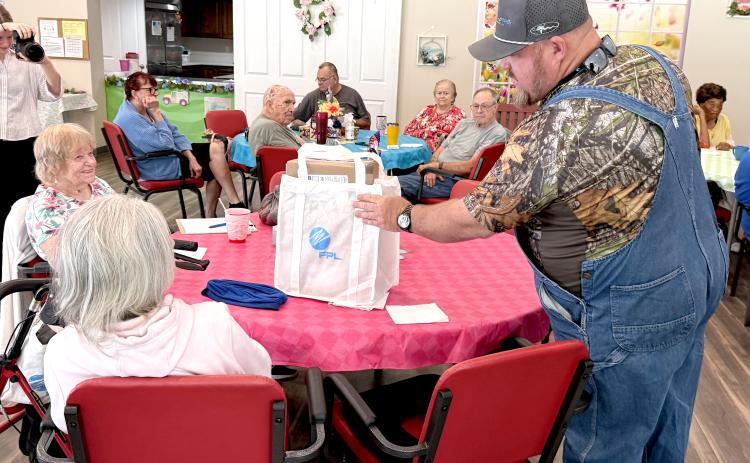 Nassau County Commissioner Klynt Farmer hands out a hurricane preparedness kit on Monday.